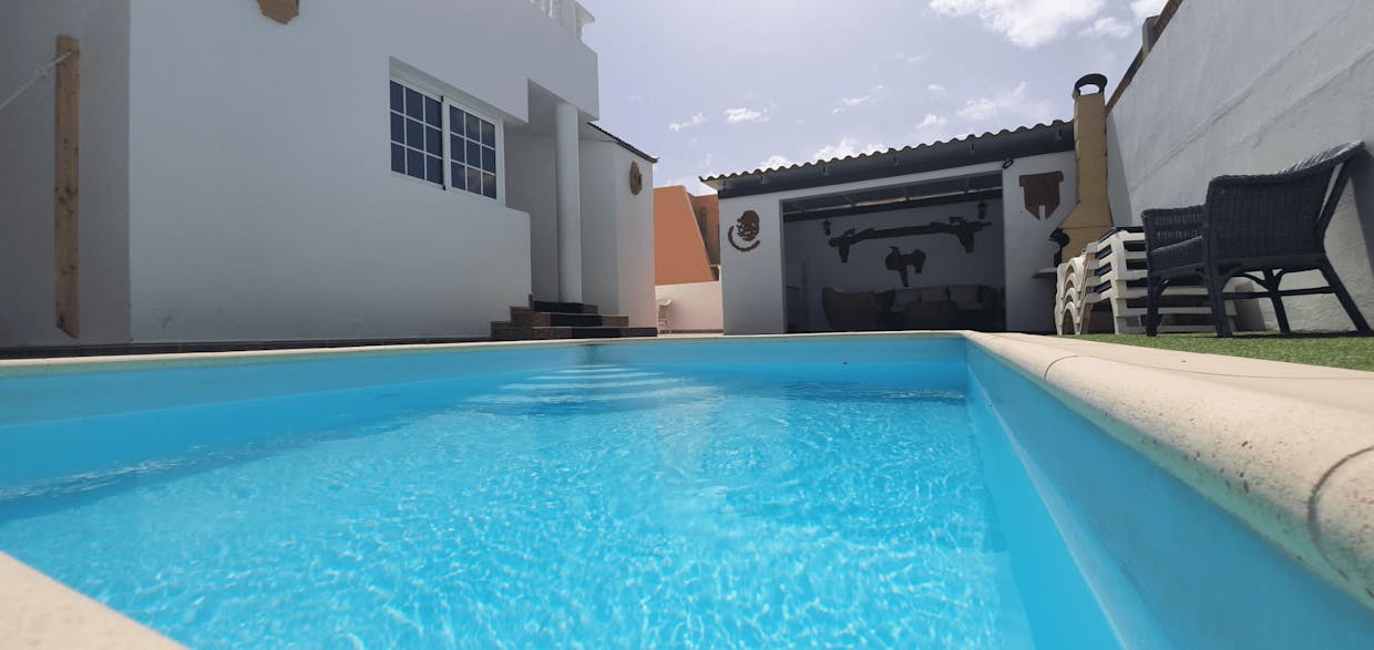 Zona exterior piscina, chill-out y barbacoa.