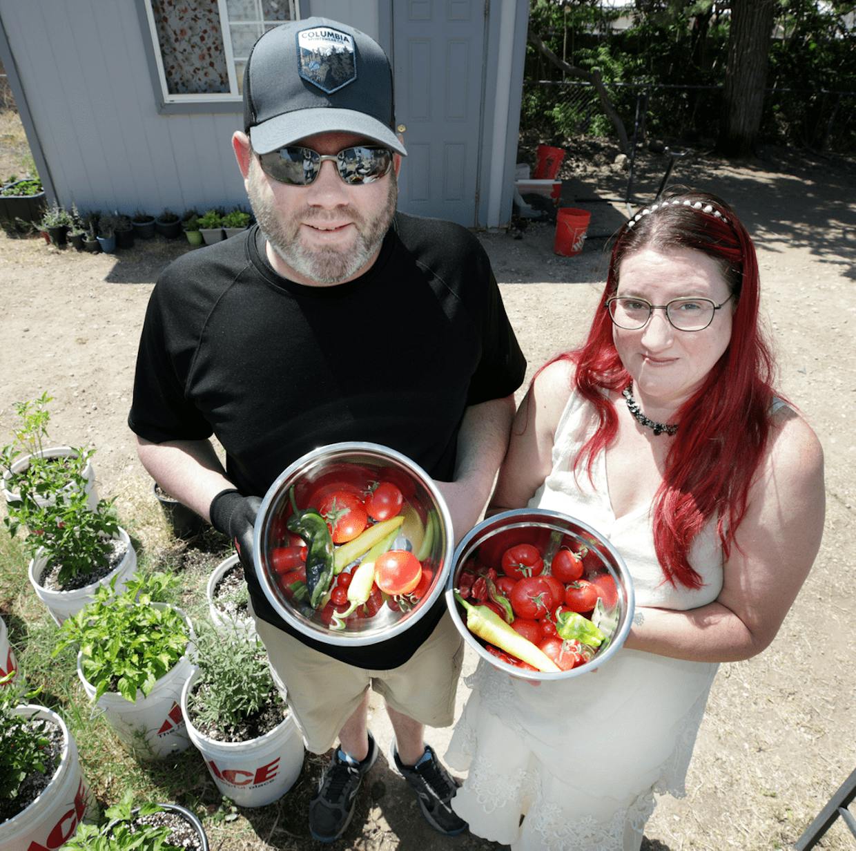 Mike Sheldon and significant other Debra Derossi display some of the harvest they collected earlier this week from their backyard container garden in San Jose.