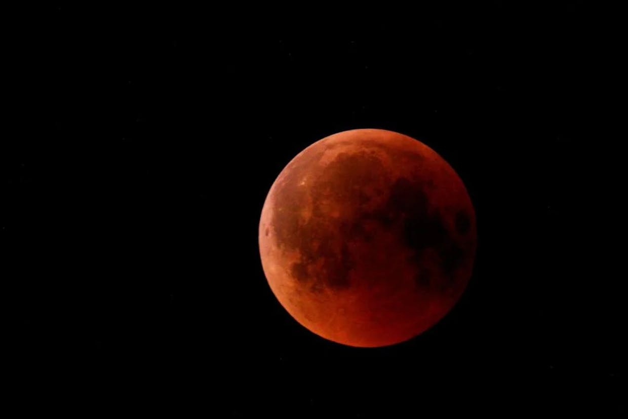 A combination of light and shadow create the screen in which the moon appears blood red. (Andrey73RUS photo)