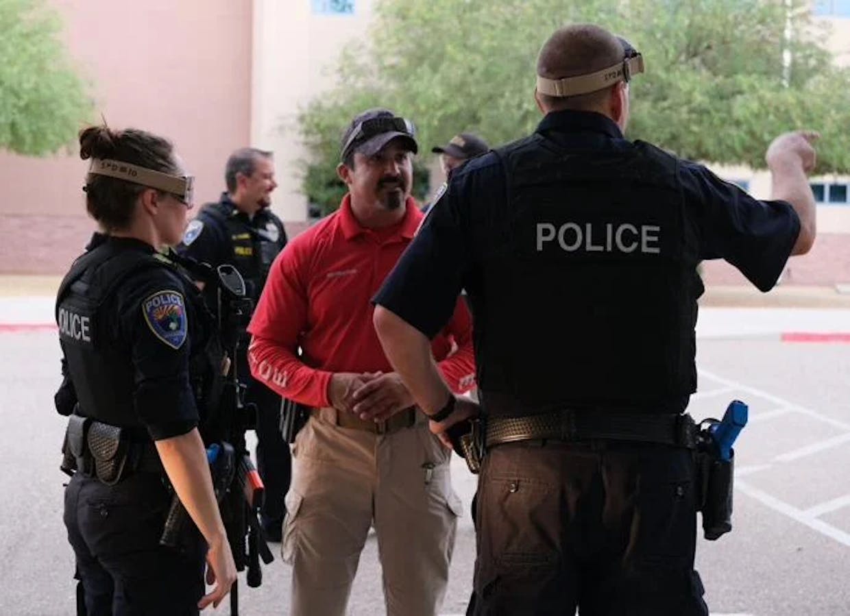 SPD officer Hector Iglecias, center, briefs officers on the scenario during active shooter training at Walden Grove High School on July 22. ( Mary Glen Hatcher/Green Valley News)