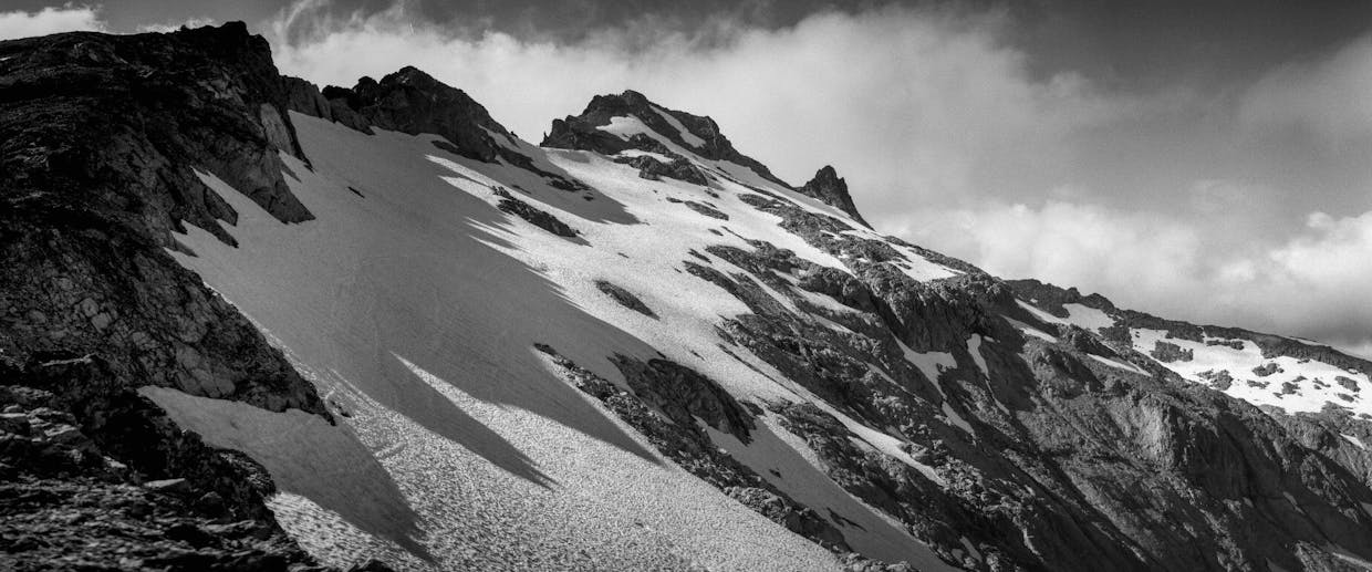 A ridgeline on Mt. Daniel casts a shadow over snowfields hugging the mountain, July 21. Scramblers commonly take a ridgetop route from left to right in order to reach the top.